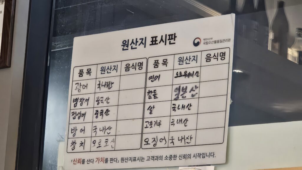 Fish origin information board at Shinhee Sushi showing Norwegian salmon domestic flounder and Moroccan tuna