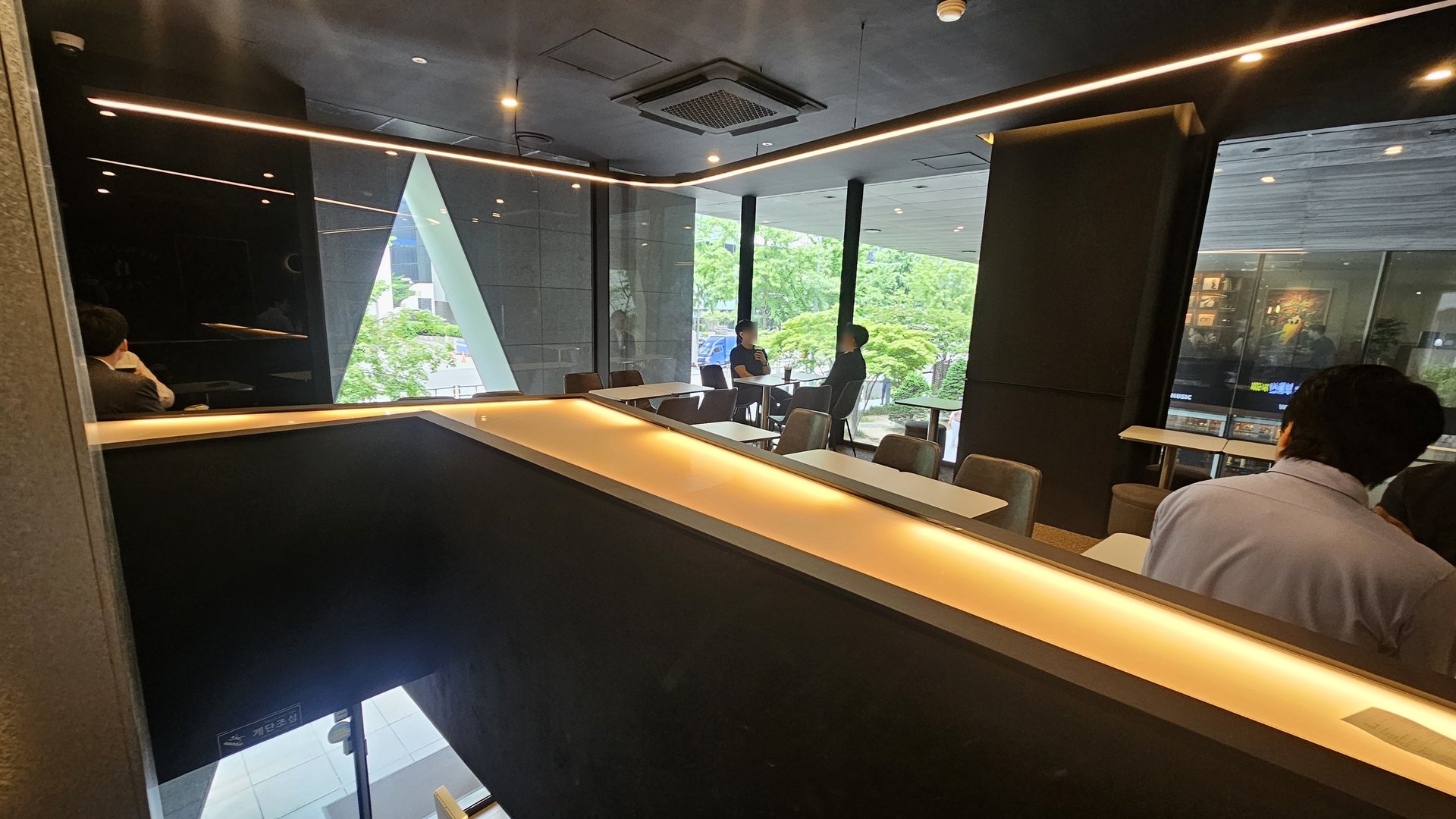 Interior seating area at Byronic Espresso Yeouido with black marble counter seats and window tables in natural daylight