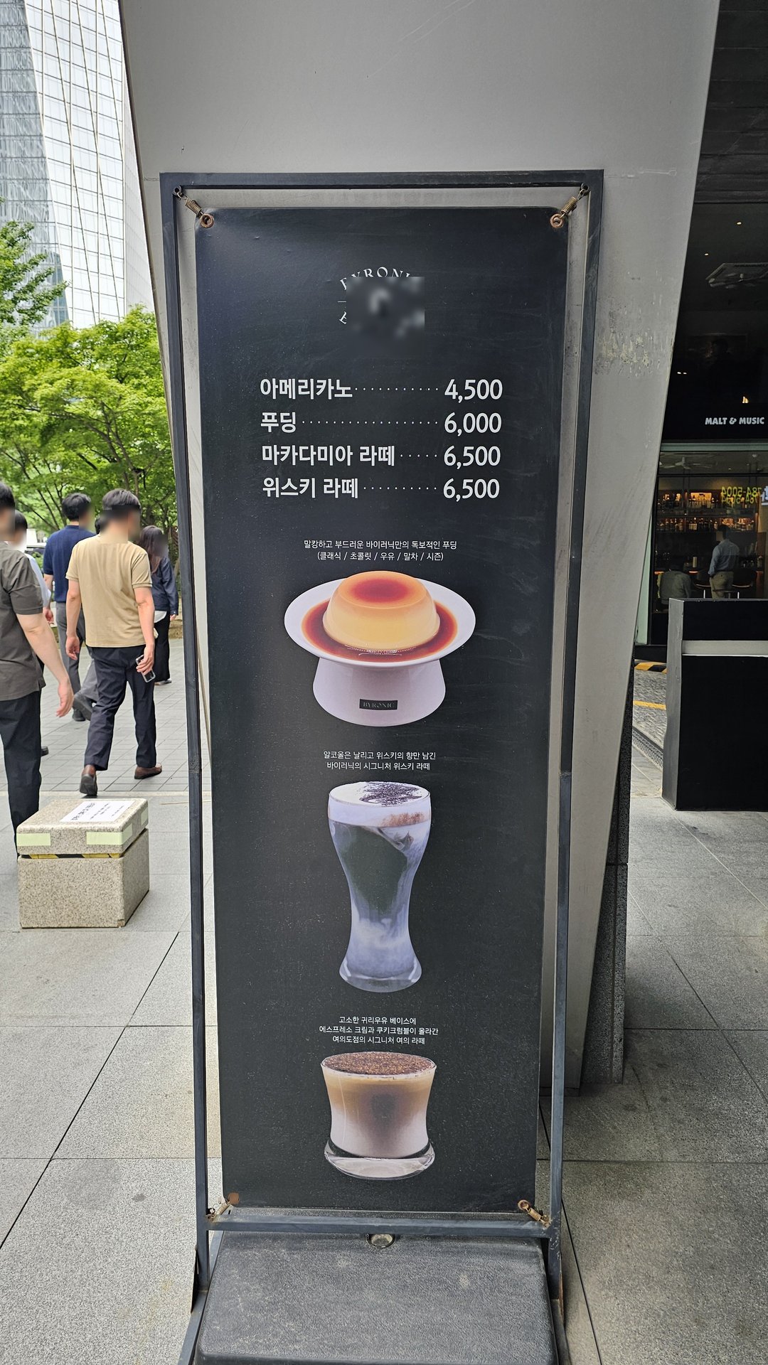 Outdoor menu board at Byronic Espresso Yeouido showing prices for Americano, Macadamia Latte, and Whisky Latte