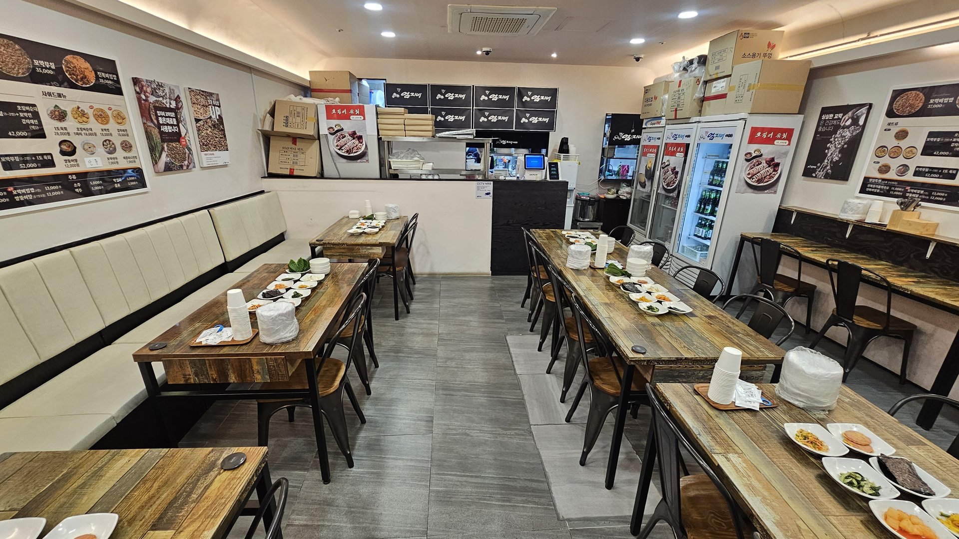 Interior of Eomjine Kkomak House with long wooden tables and sofa-style bench seating