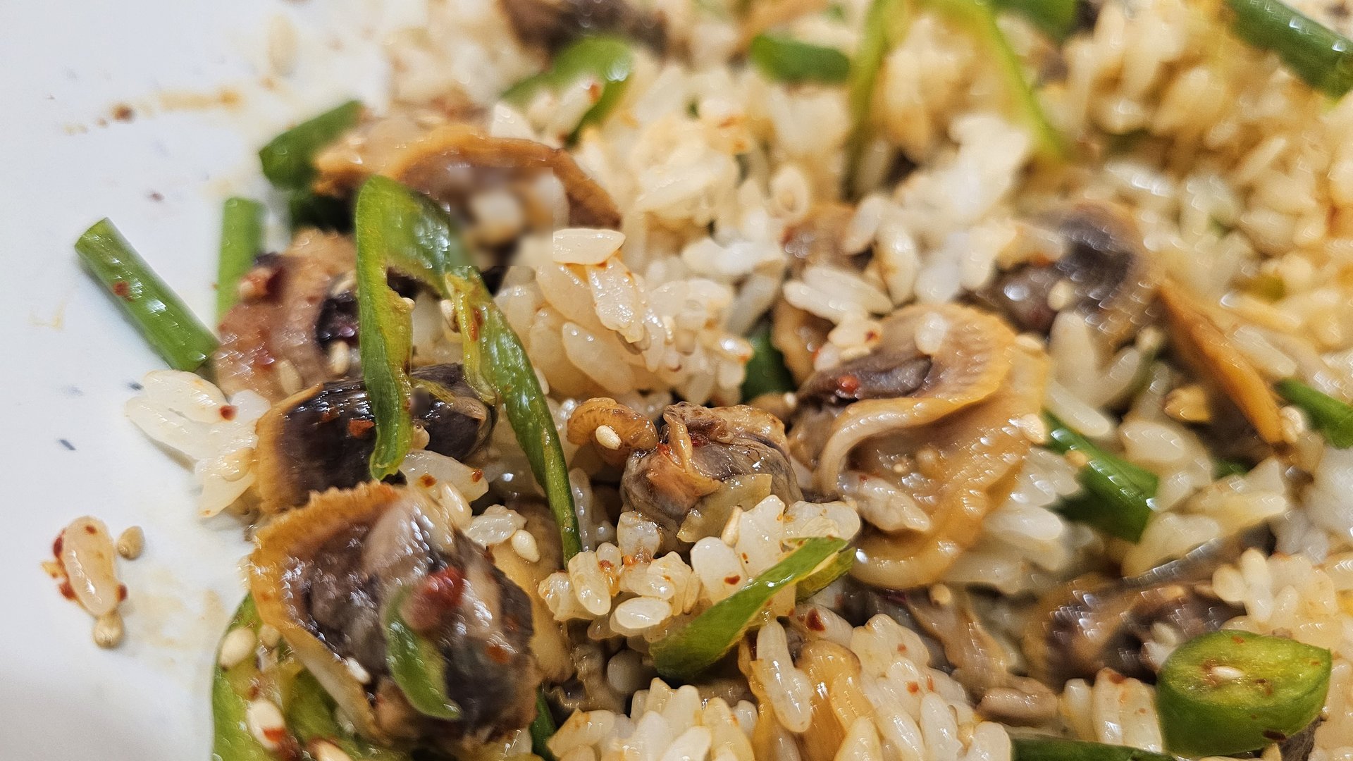 Close-up of mixed kkokak bibimbap showing cockles, rice, gochugaru seasoning and sesame at Eomjine Kkomak House Yeouido