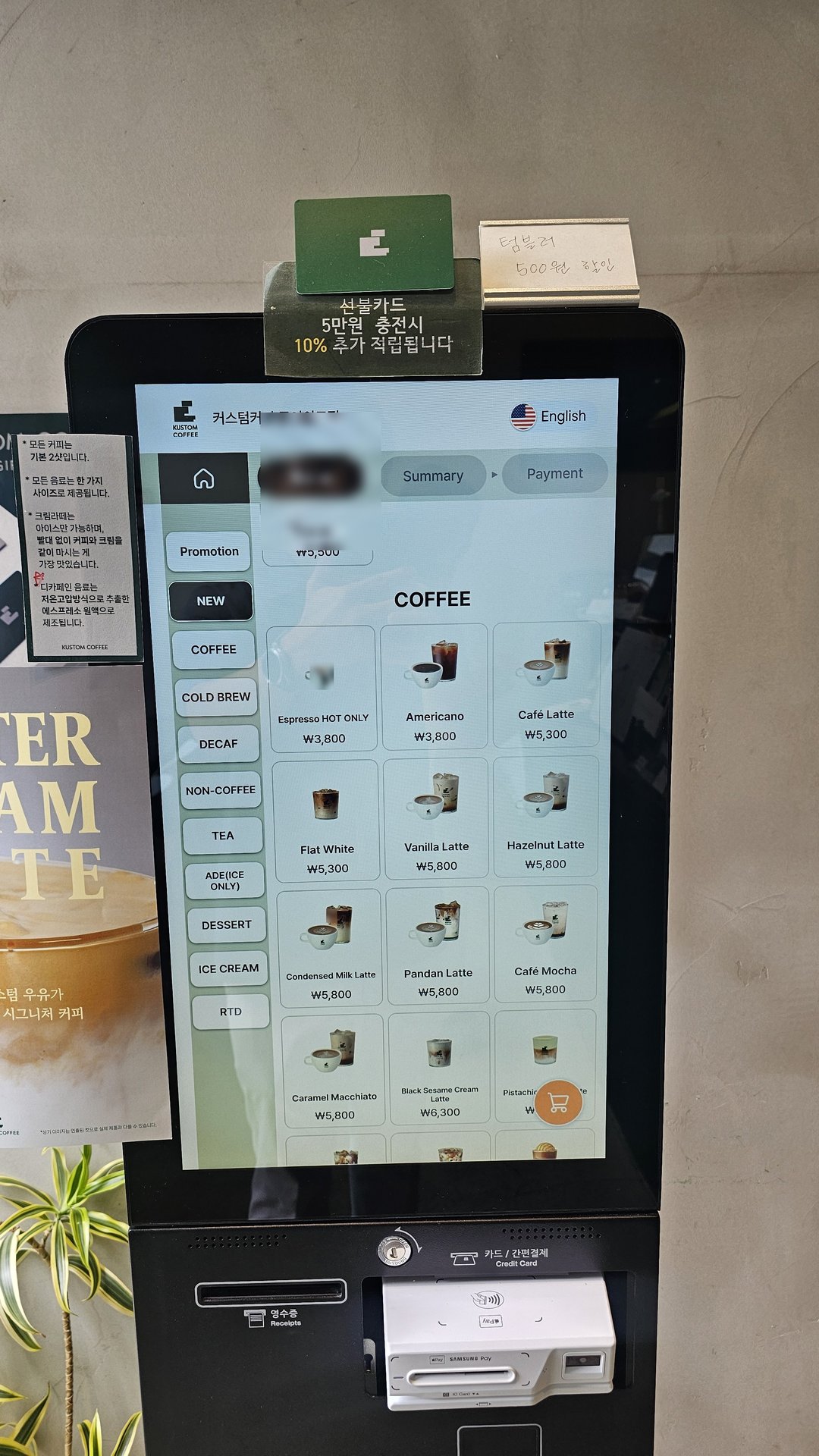 Kustom Coffee kiosk ordering screen in English showing cafe latte hazelnut latte and mocha prices