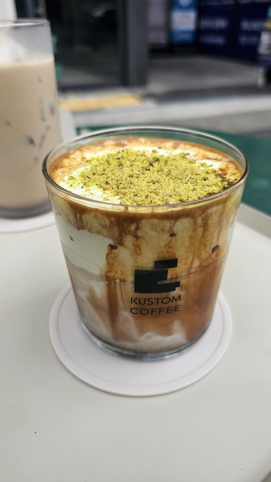Close-up of pistachio cream latte with thick cream layer and heavy pistachio powder at Kustom Coffee Yeouido