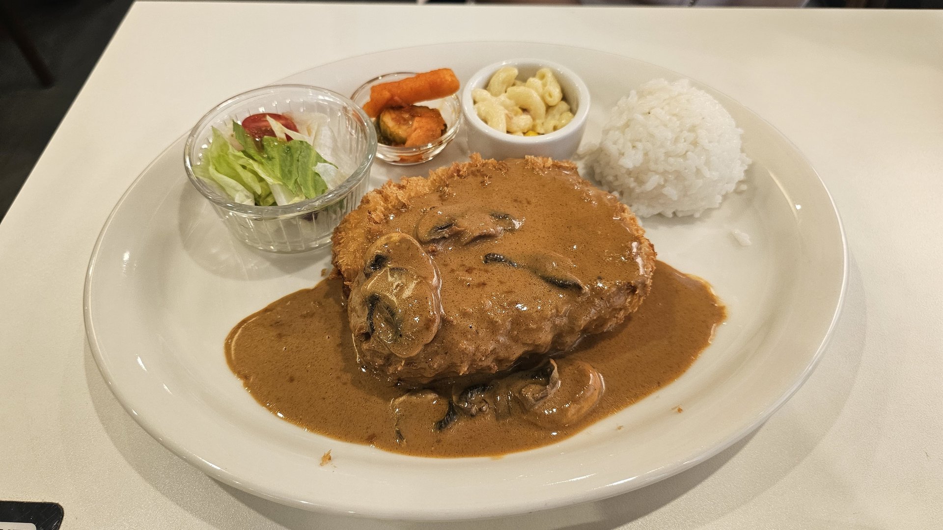 Pork donkatsu with mushroom demi-glace sauce full plate with salad, macaroni salad, pickled vegetables and rice at Keebo