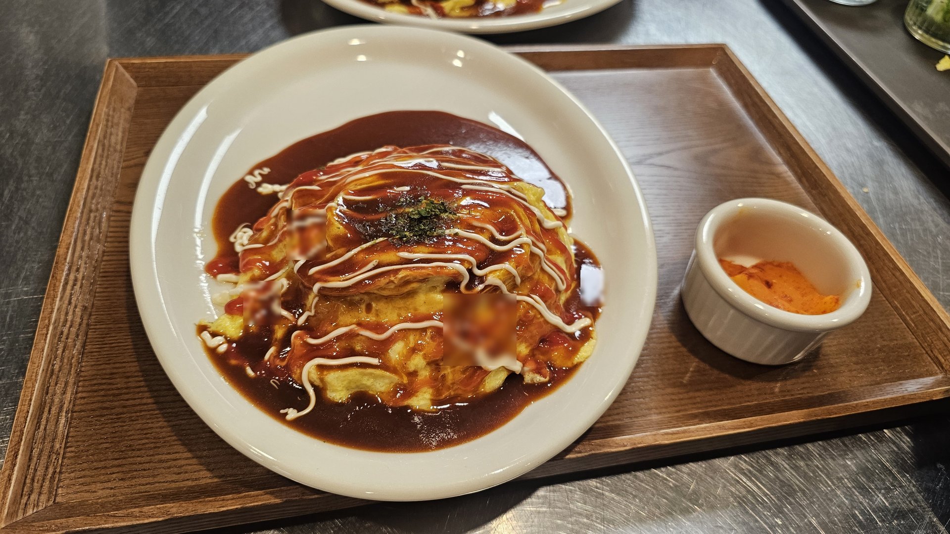 Omurice with demi-glace sauce, mayo drizzle, and parsley topping served on wooden tray at Keebo Rock and Roll