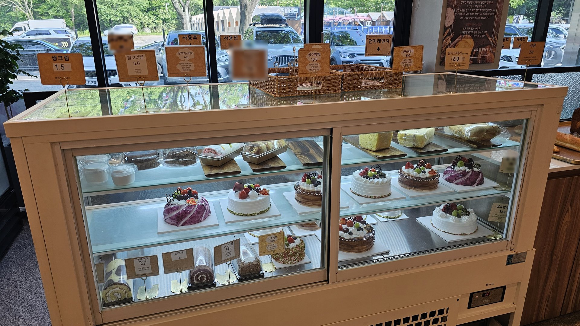 Refrigerated cake showcase with strawberry cake, chocolate cake, and roll cake at Mochang-po Bread Cafe Boryeong