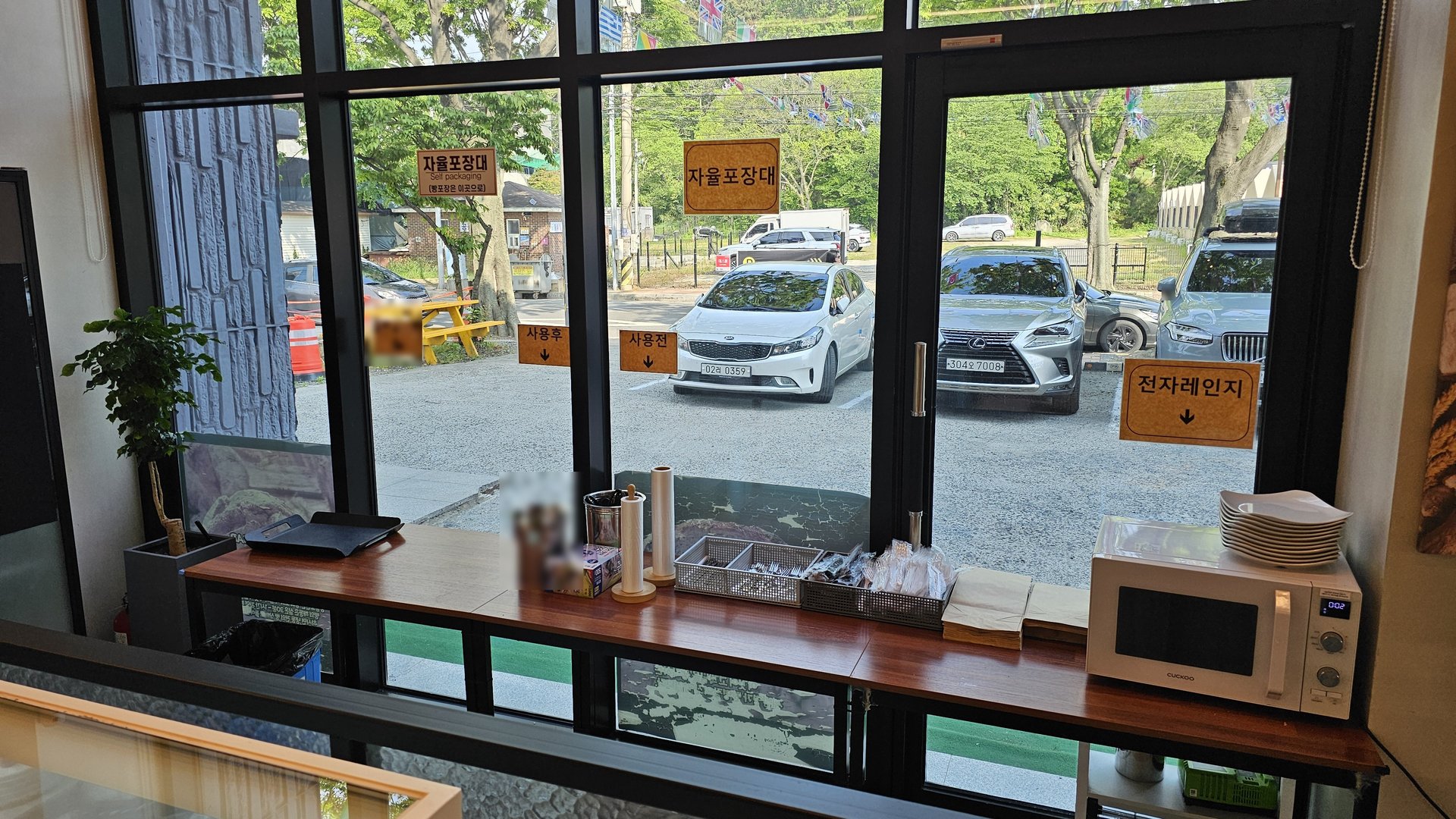 Self-service corner with microwave and bread packaging station at Mochang-po Bread Cafe