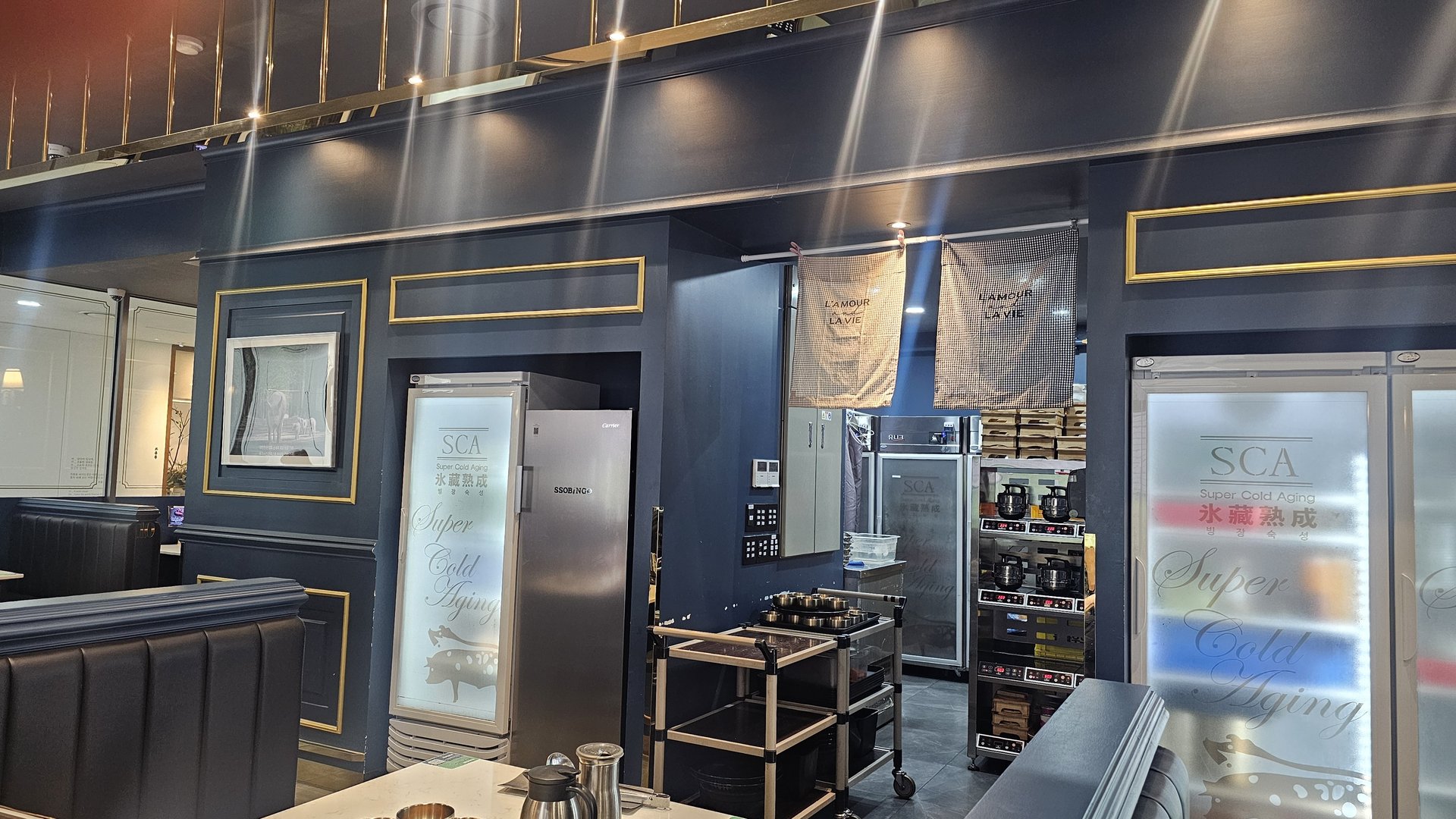 Shindosegi Yeouido interior with navy and gold decor, SCA Super Cold Aging refrigerators, and dining seating area