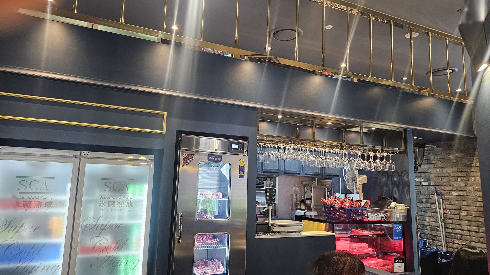 SCA aged meat showcase refrigerator and wine glass rack inside Shindosegi Yeouido open kitchen