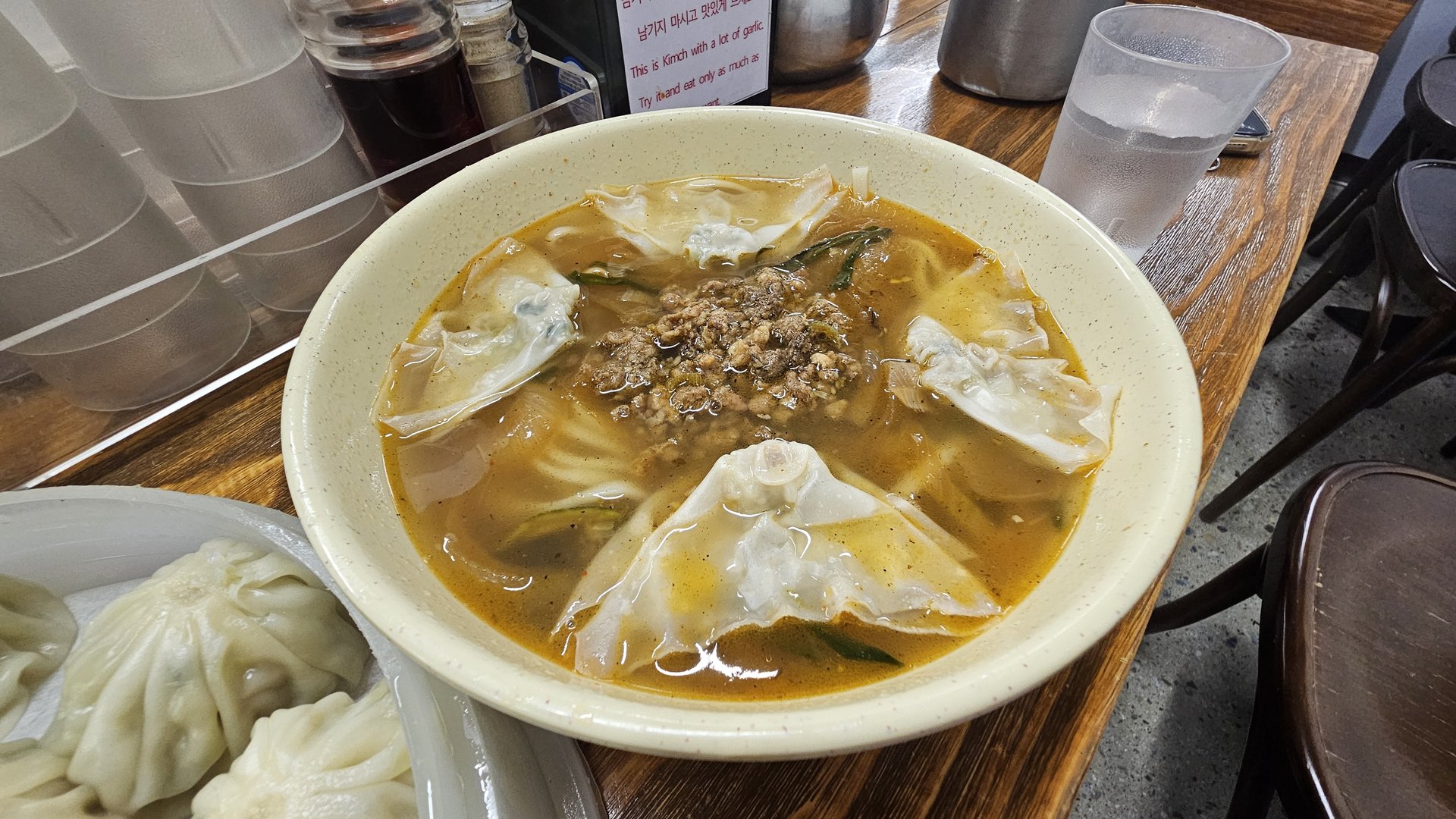 Kalguksu knife-cut noodle soup with minced meat and thick noodles in bowl at Myeongdong Gyoja