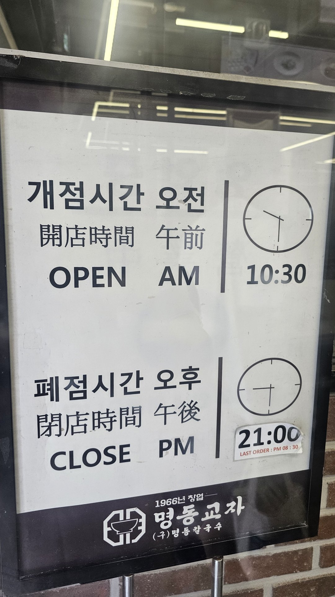 Operating hours sign at Myeongdong Gyoja showing open 10:30 AM close 9:00 PM