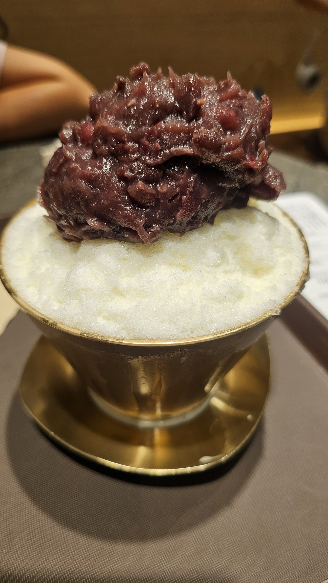 Overhead view of red bean bingsu in brass bowl at Patgodang — snow ice topped with sweet red beans