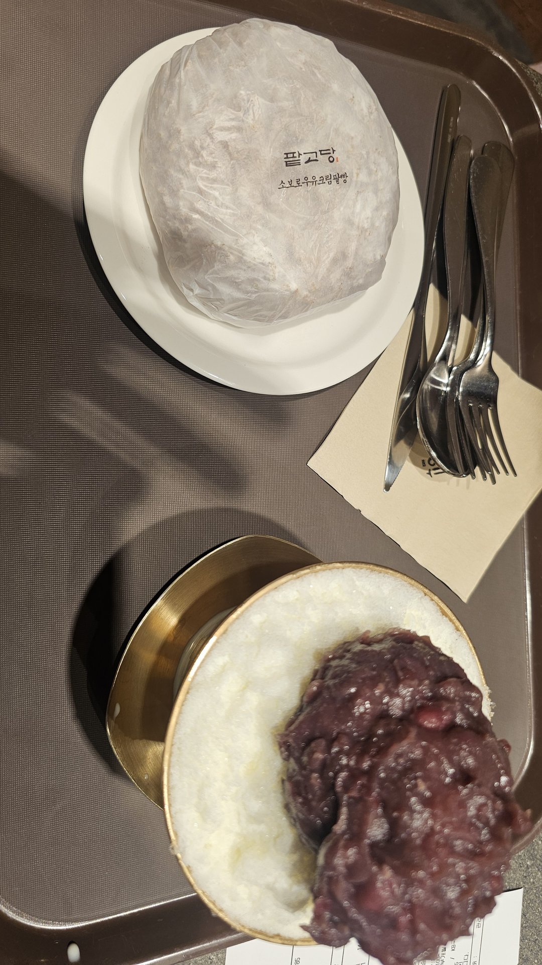 Full tray at Patgodang with red bean bingsu in brass bowl and soboro red bean cream bread on white plate