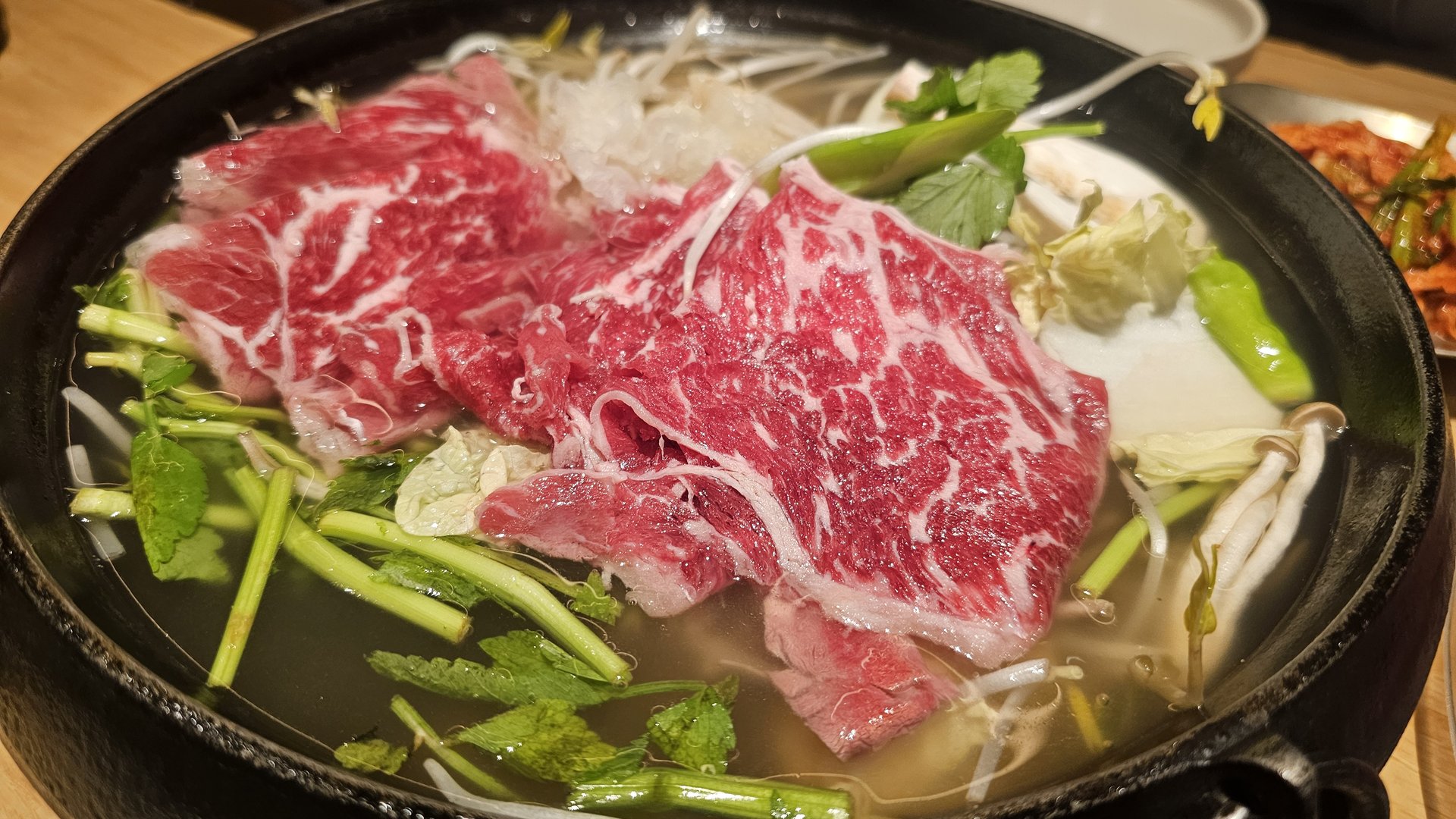 Beef and vegetables cooking in the shabu shabu broth at Jeil Myeonso Yeouido