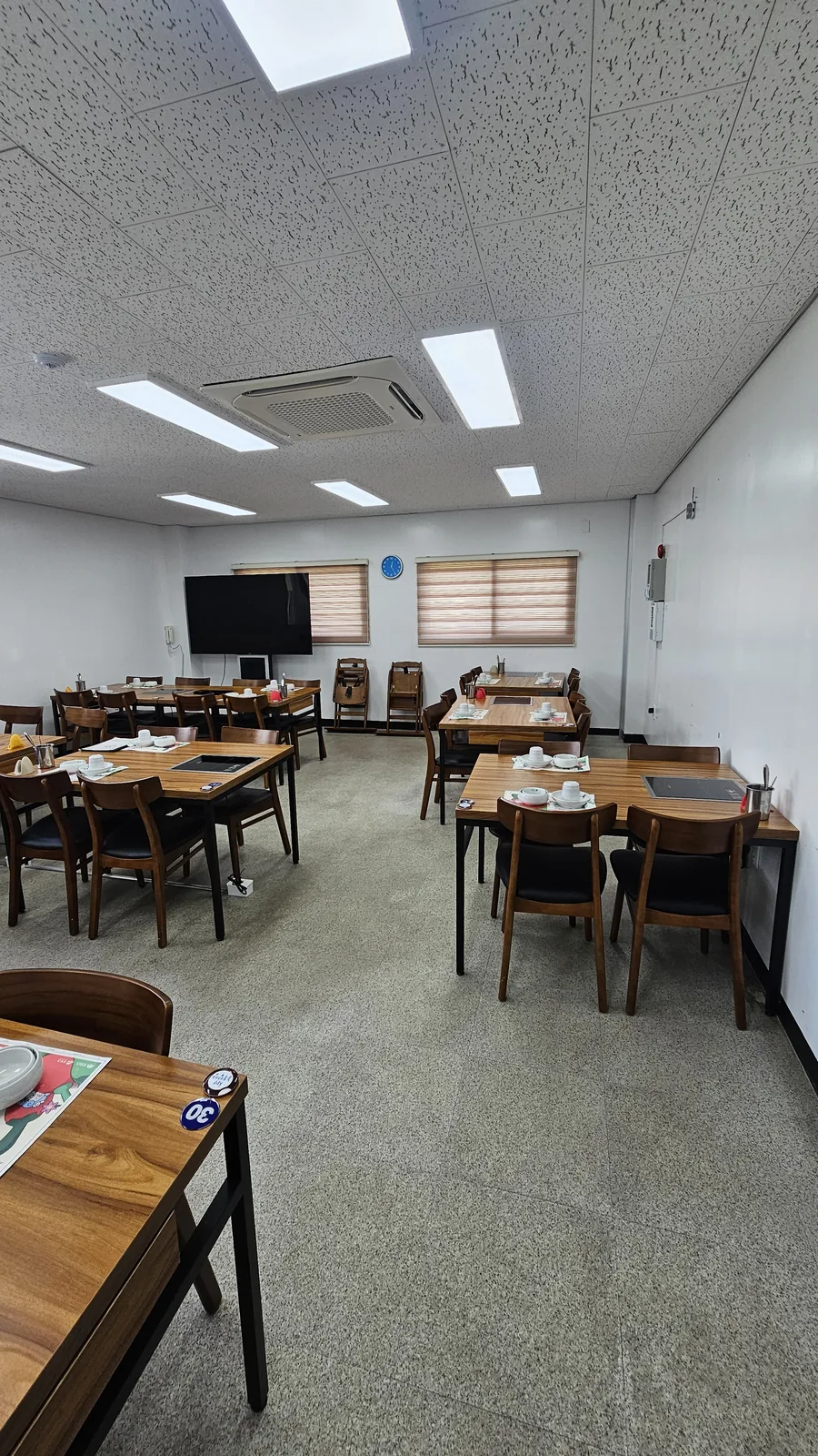 Empty dining hall interior at Nongbu Bapsang Cheongyang with neatly set tables before lunch service