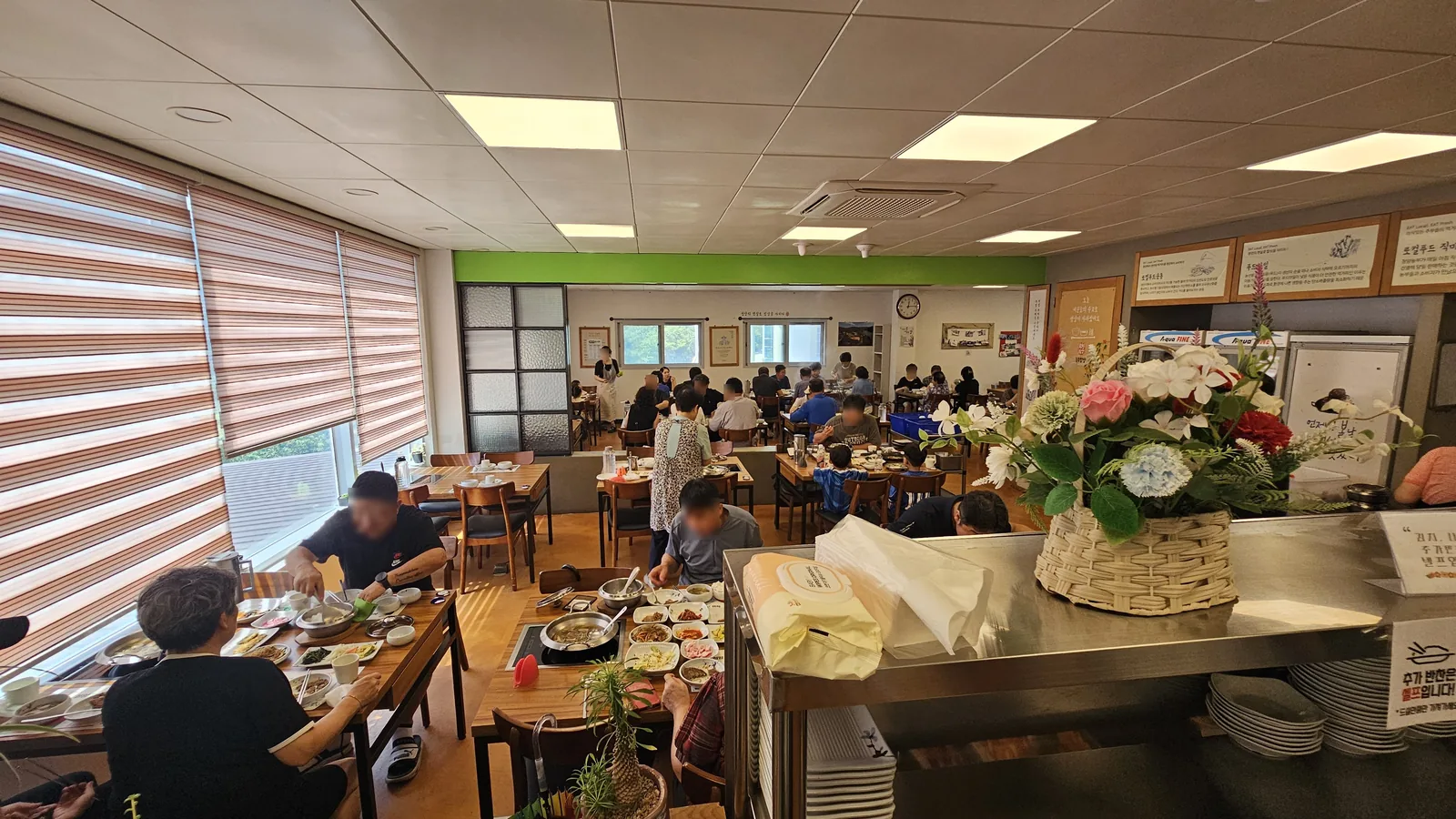 Busy lunchtime service at Nongbu Bapsang with full tables and self-service banchan bar in background