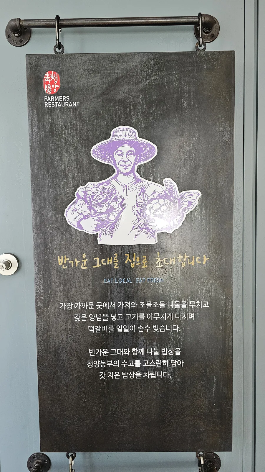 Nongbu Bapsang EAT LOCAL EAT FRESH promotional sign with illustrated farmer and local food mission statement