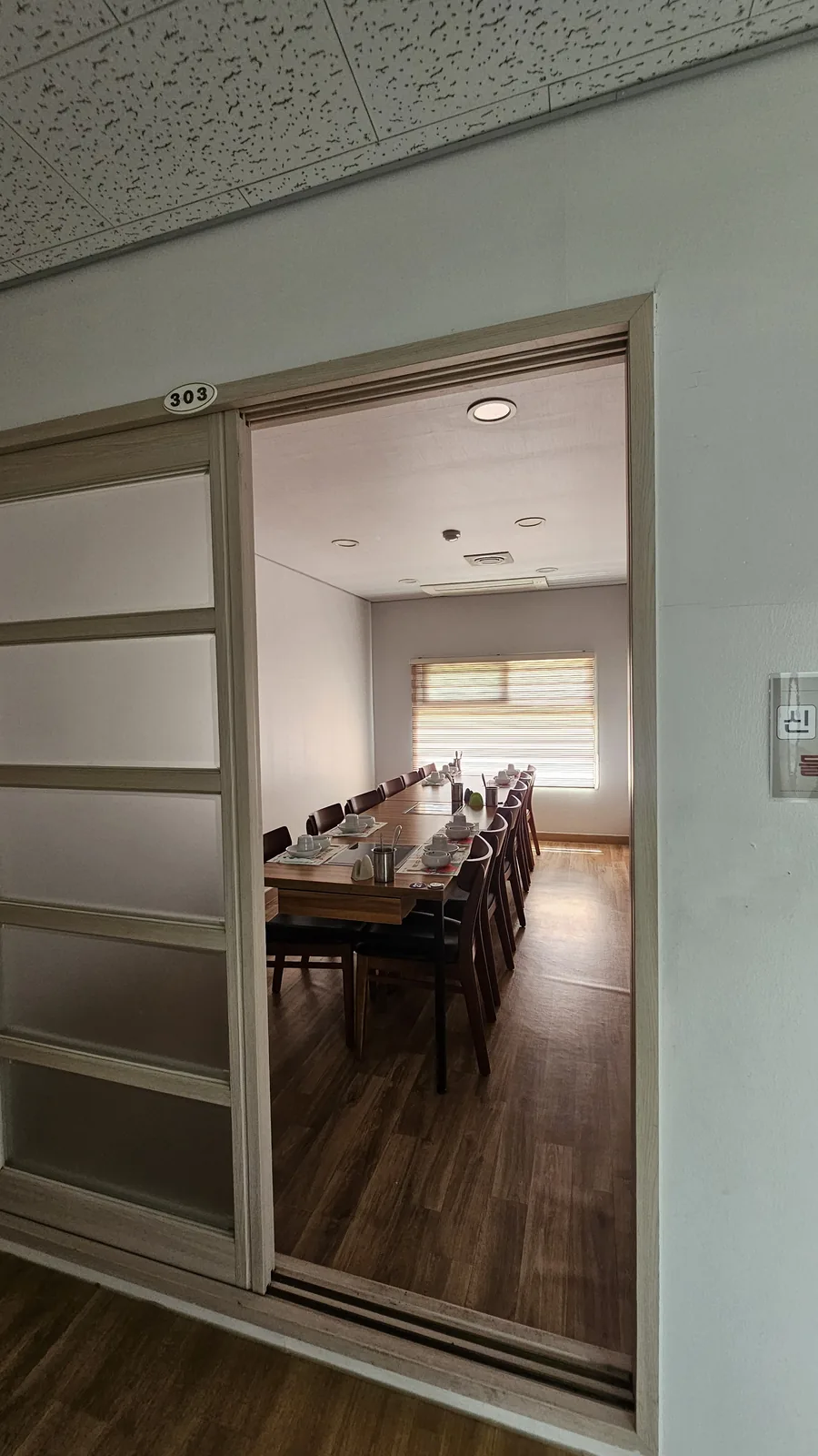 Sliding door entrance to group room 303 at Nongbu Bapsang with pre-set table visible inside