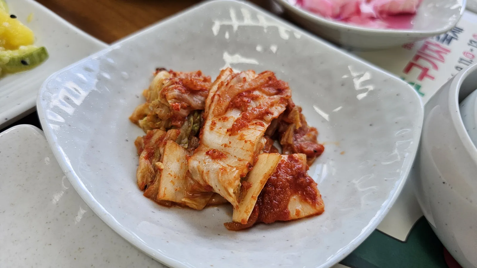 Napa cabbage kimchi close-up at Nongbu Bapsang with red chili seasoning and traditional fermentation