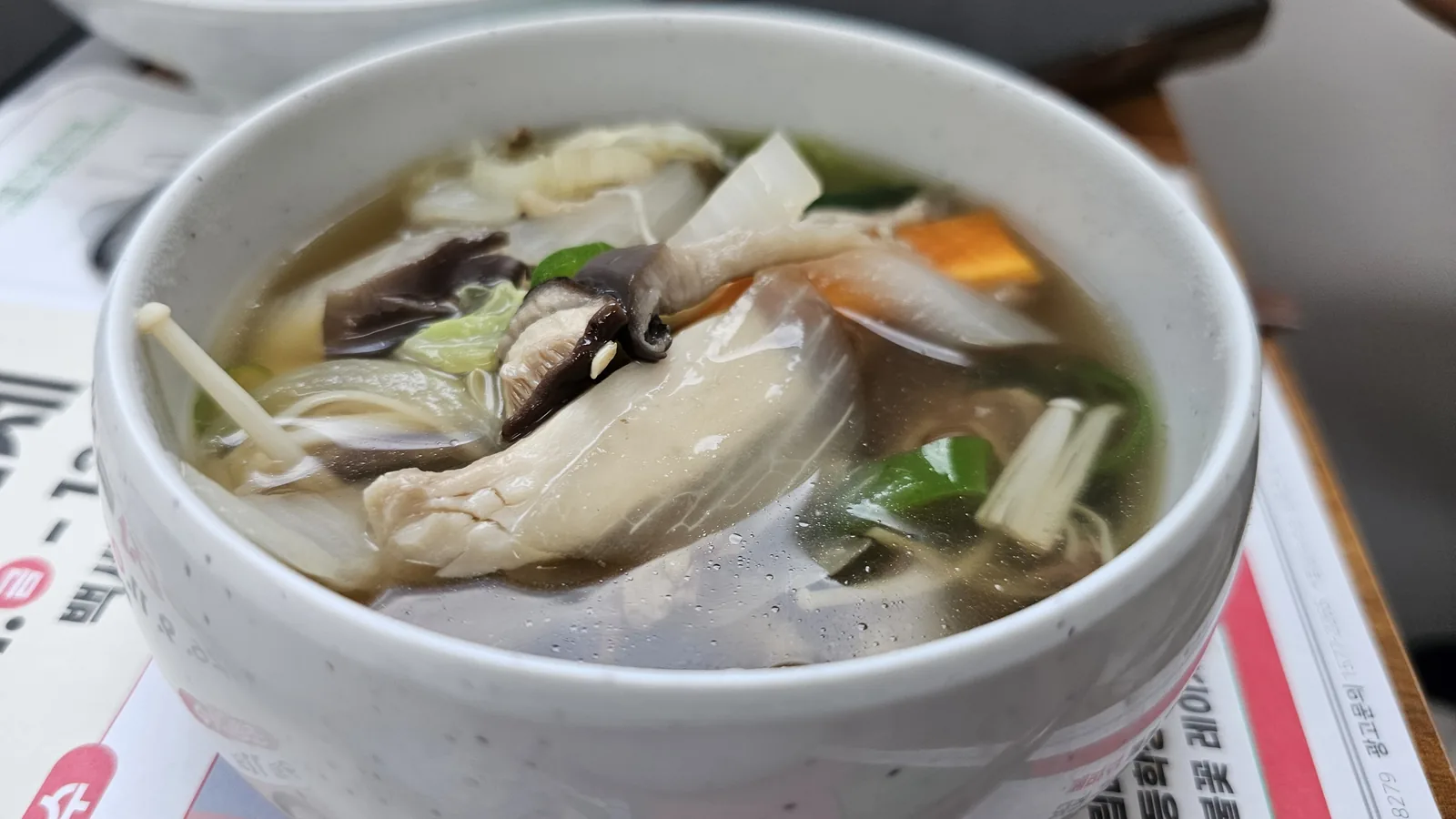 Mushroom jeongol soup bowl at Nongbu Bapsang with shiitake, oyster mushrooms, black wood ear fungus, carrot, and green onion