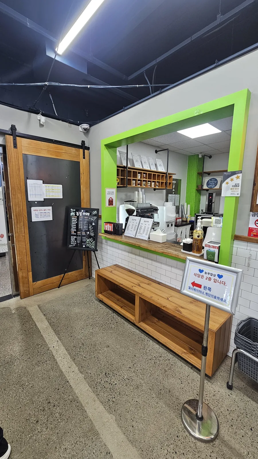 Cafe Bomnal coffee counter on the first floor of the Nongbu Bapsang building with sign directing diners upstairs
